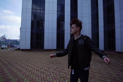 Full length of young man looking at city buildings