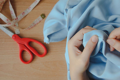 Close up asian woman fixing repairing clothing. top view.