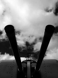 Low angle view of factory against cloudy sky