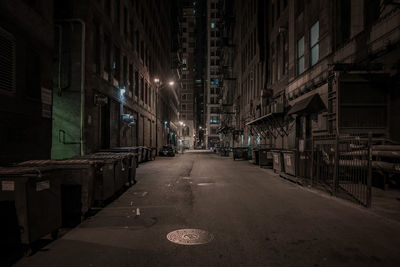 Empty street amidst buildings at night