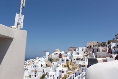 Buildings in town against clear blue sky