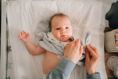 Portrait of cute baby lying on bed