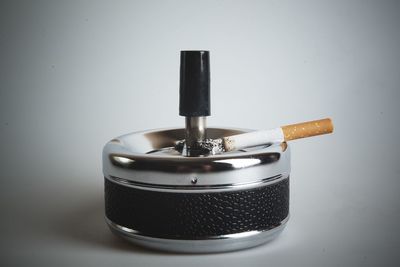 Close-up of cigarette on table against gray background