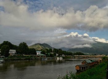 Scenic view of lake by buildings against sky