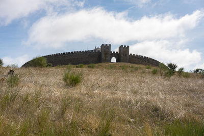 Old ruin on field against sky