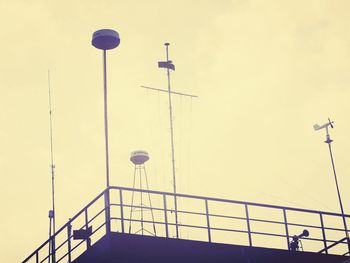 Low angle view of antennas on ship against sky