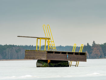 Empty chair on field against clear sky