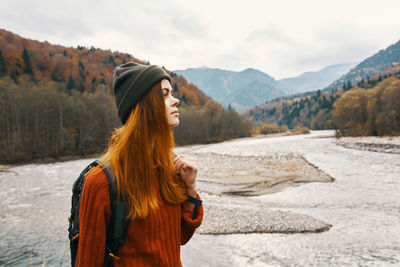 Woman standing on mountain against sky