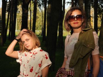 Portrait of happy woman standing against trees