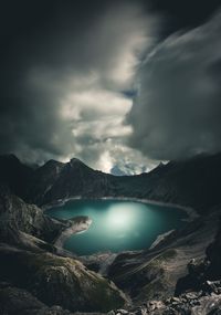 Scenic view of lake and mountains against cloudy sky