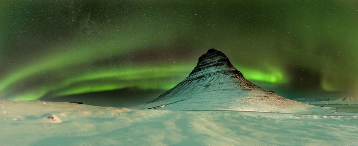 Scenic view of snowcapped mountain against sky at night