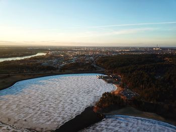 High angle view of river amidst cityscape against sky