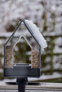 Snow on bird feeder during winter