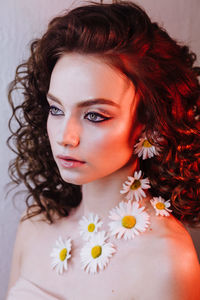 Close-up of beautiful young woman wearing flowers and make-up