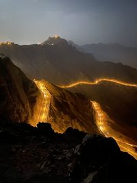 Aerial view of land and mountains against sky at night