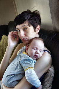 Portrait of mother with sleeping son at home