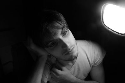 Close-up of depressed boy sitting by window