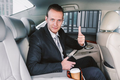 Portrait of young businessman sitting in car