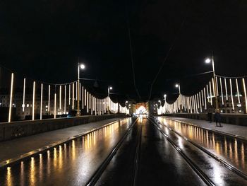 Illuminated bridge over street at night