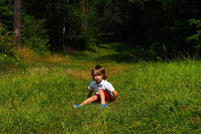 Picture of a little boy sitting on field