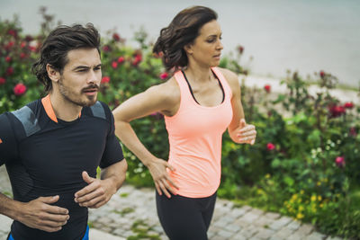 Male and female athletes jogging on footpath