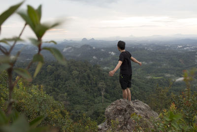 Man standing on rock looking at mountains