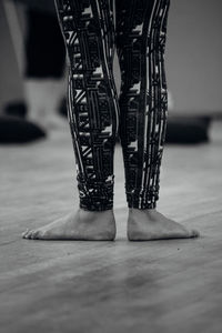 Low section of woman standing on hardwood floor