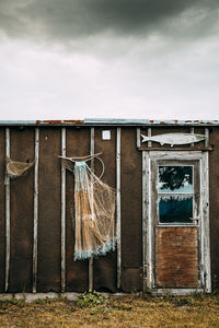 Clothes hanging on wall by building against sky