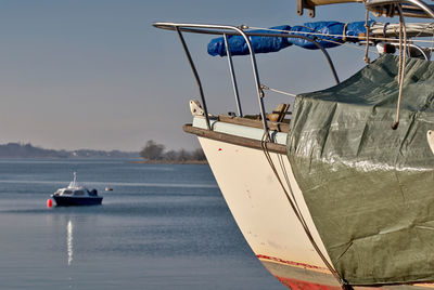 Fishing boat sailing in sea against clear sky