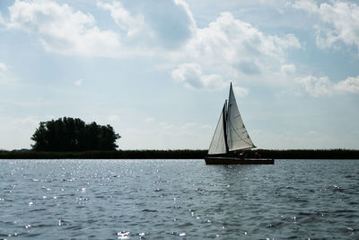 Sailboat sailing on sea against sky