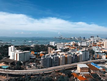 High angle view of city buildings against cloudy sky