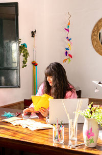 Rear view of woman sitting at home