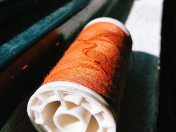 Close-up of brown thread spool on window sill at home