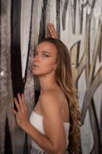 Portrait of beautiful young woman leaning outdoors