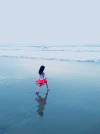 Full length of woman standing in water