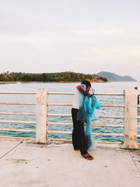 Rear view of people looking at sea against sky