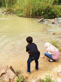 Rear view of boy on lake