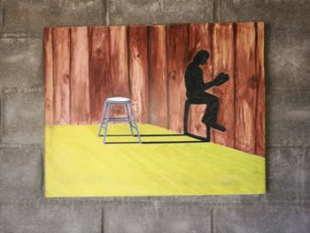 Full length of man using mobile phone on wall