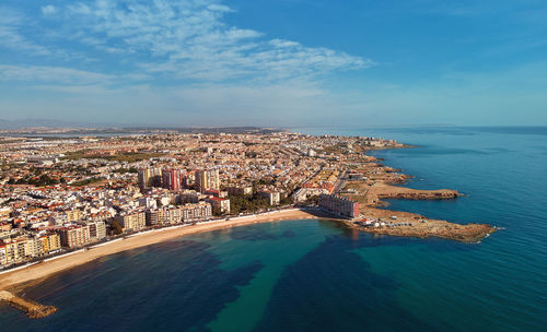 High angle view of sea and buildings against sky