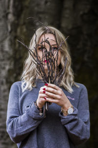 Portrait of young woman holding sticks