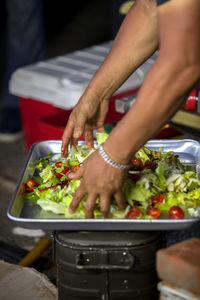 Man tossing salad in tray