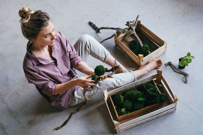 High angle view of woman holding potted plant