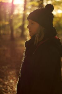 Side view of woman against trees at night