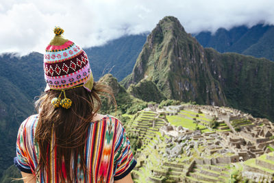 Peru, machu picchu region, female traveler looking at machu picchu citadel and huayna mountain