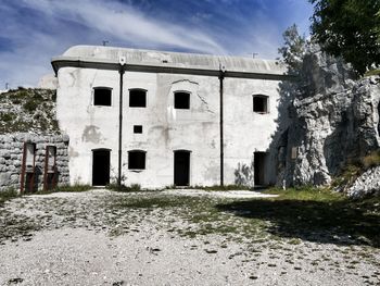 Abandoned building on field against sky