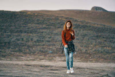 Portrait of smiling young woman standing on land