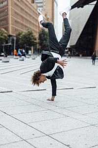 Excited businessman doing handstand on square at potsdamer platz