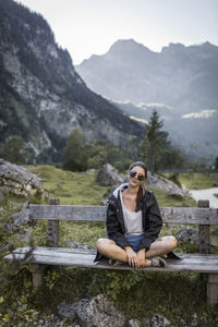 Full length of woman sitting on mountain