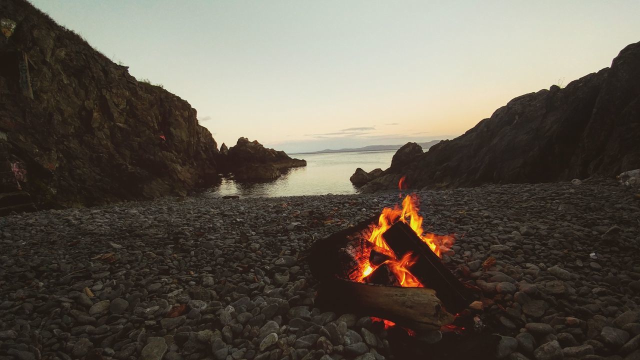 BONFIRE BY SEA AGAINST CLEAR SKY