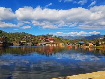 Scenic view of lake by buildings against sky